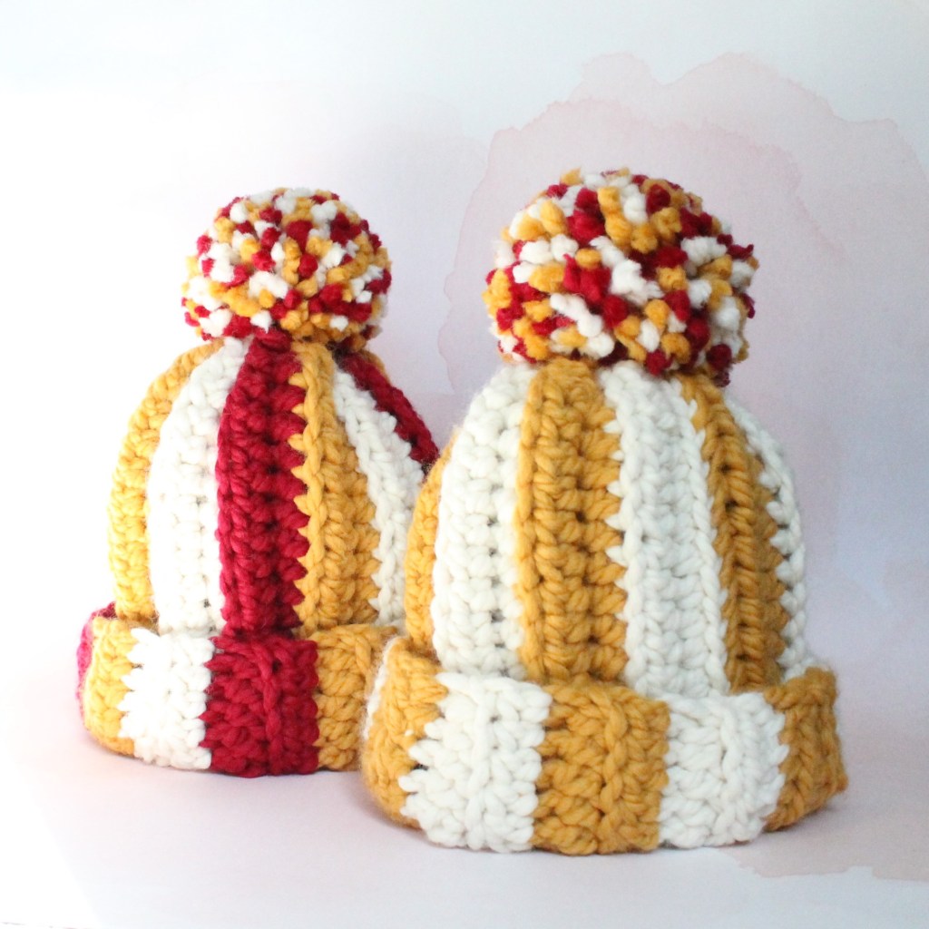 Two crochet hats in red, yellow, and white in support of the Kansas City Chiefs. Go Taylor's boyfriend!