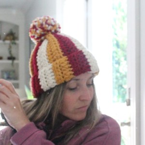 Woman wearing crochet hat in Kansas City Chiefs colors